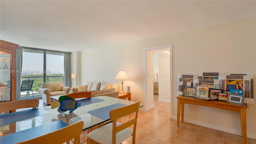 Open-concept interior featuring large-format tile flooring and floor-to-ceiling glass doors providing access to a private balcony