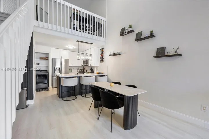Double-height living area featuring a wood-finish staircase
