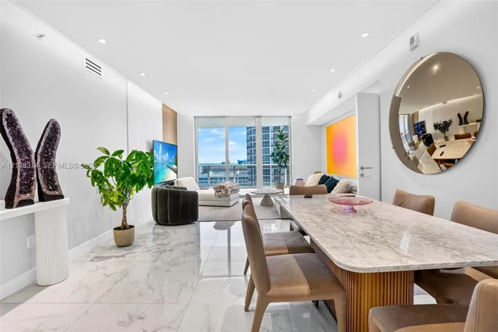 Open-concept living space featuring large-format polished stone flooring, recessed ceiling lighting, and floor-to-ceiling glass windows