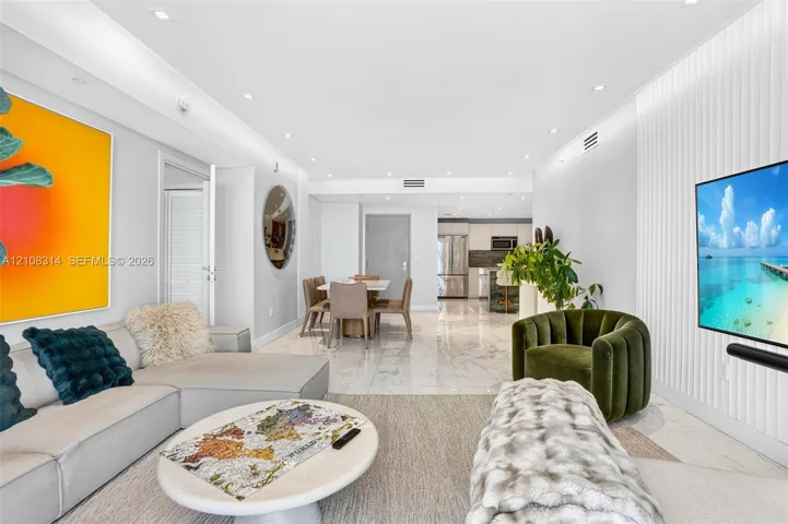 Open-concept living space featuring high-gloss large-format tile flooring, recessed ceiling lighting, and a floor-to-ceiling vertical slat accent wall