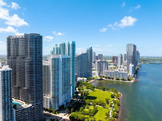 High-rise coastal cityscape featuring waterfront access, expansive green space, and architectural tower structures