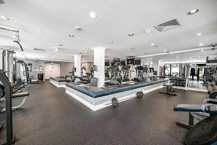 Fitness space featuring rubberized flooring, recessed lighting, and wall-to-wall mirrors