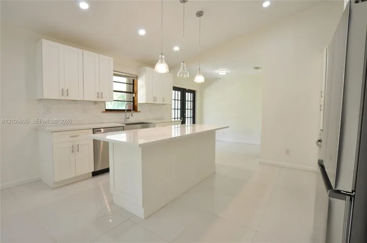 Kitchen featuring white cabinetry, quartz countertops, a central island, recessed lighting, and stainless steel appliances