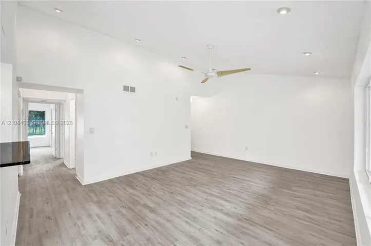 Vaulted ceilings featuring recessed lighting, a modern ceiling fan, and wood-finish flooring