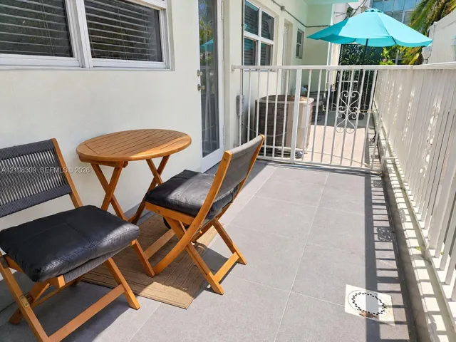 Private patio featuring large-format tile flooring and a perimeter white metal railing