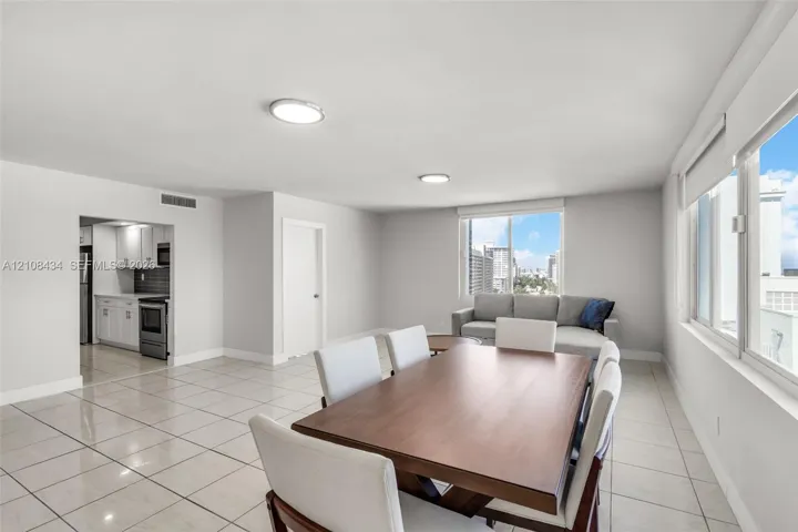 Open-concept interior featuring large-format ceramic tile flooring, neutral walls, recessed ceiling lighting, and expansive windows