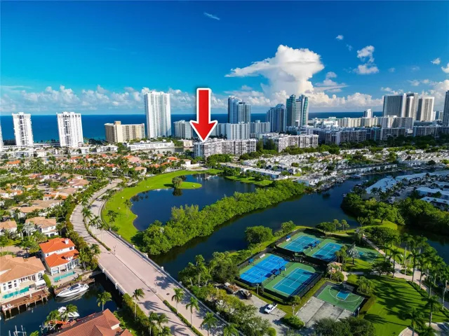 Aerial perspective of residential building with proximity to water features, tennis courts, and basketball court
