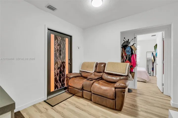 Entryway featuring wood-finish flooring and a decorative front door with an integrated vertical glass panel