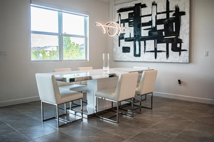 Neutral-toned room featuring large-format stone-tile flooring, a window with horizontal blinds, and a contemporary sculptural LED pendant light fixture