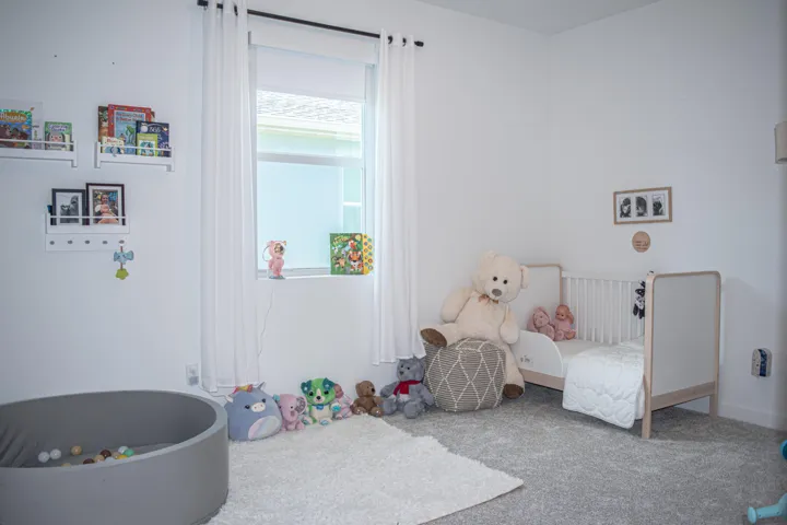 Neutral-toned wall-to-wall carpeting, window with central sill, and wall-mounted shelving units
