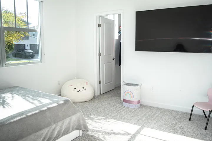 Neutral-toned carpeting, multi-pane window, and an interior door with a walk-in closet