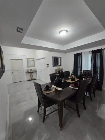 Tray ceiling, large-format tile flooring, and multi-panel interior doors