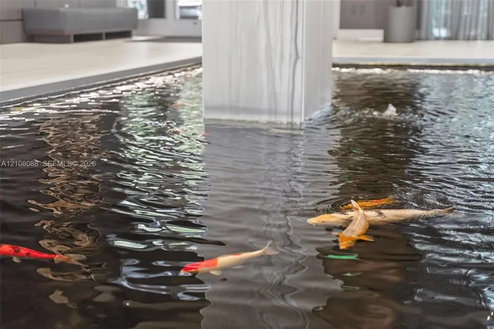 Indoor water feature with koi, stone-finish column, and light-toned flooring