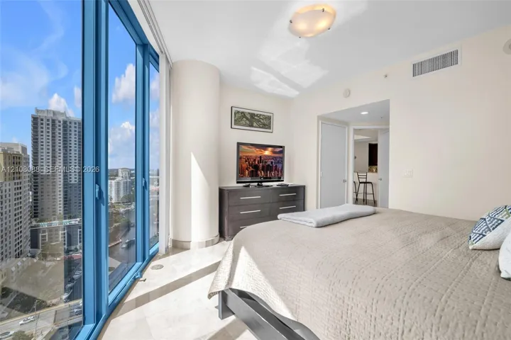 Floor-to-ceiling windows, polished stone flooring, and structural rounded column