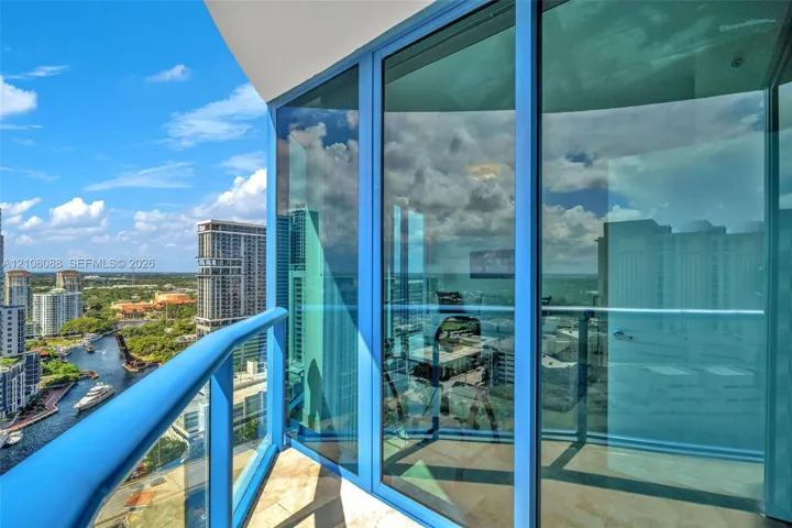Private balcony featuring floor-to-ceiling glass paneling, metal railings, and stone-tile flooring