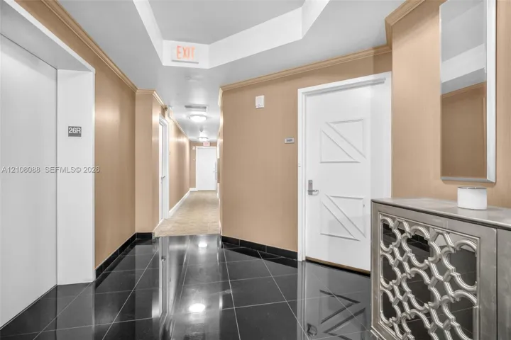 Semi Private Foyer Polished black tile flooring, beige wall surfacing, recessed tray ceiling, and white paneled doors