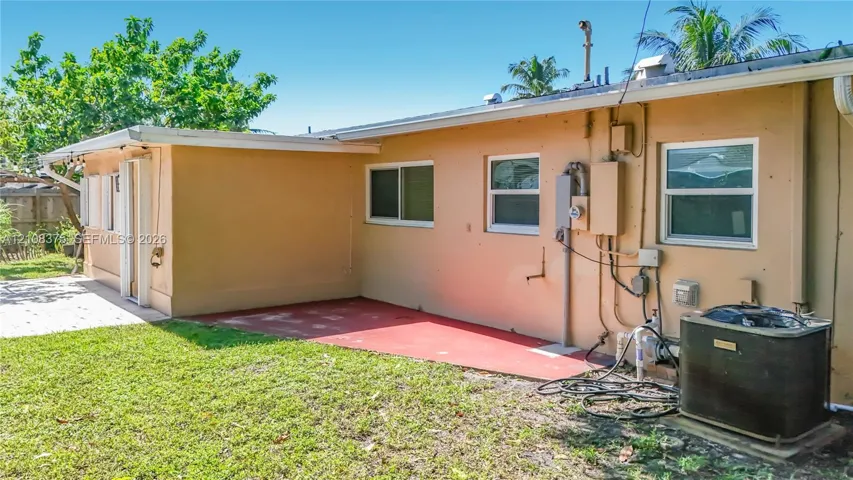 Exterior view featuring a concrete patio, horizontal sliding windows, and a dedicated central air conditioning unit