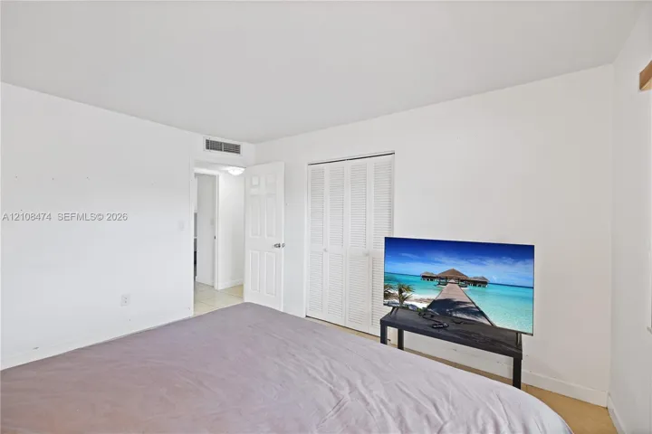 Neutral interior room featuring white walls, a white bi-fold louvered closet door, and a white interior swing door