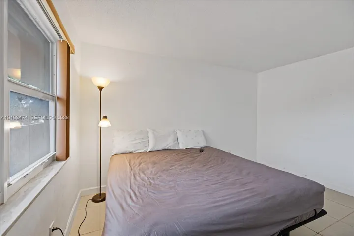 Neutral-toned tile flooring and single-hung window with a deep sill