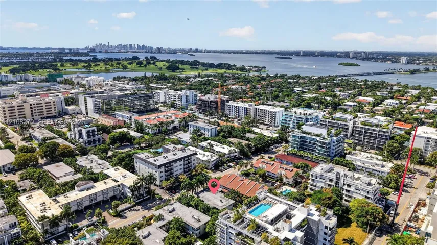 Aerial perspective of coastal neighborhood featuring mature palm trees and proximity to open water