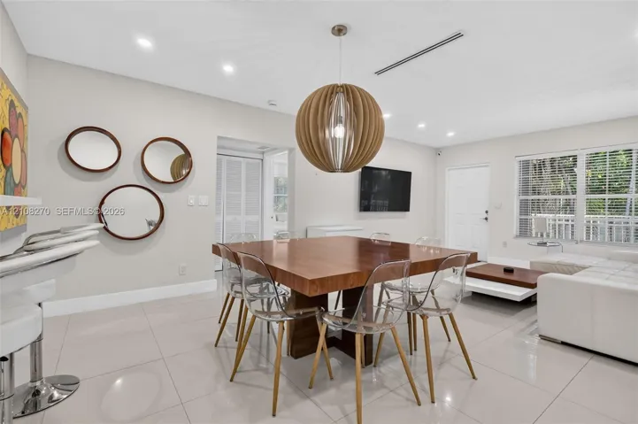 Large-format neutral floor tiling, recessed lighting, and a prominent spherical pendant light fixture
