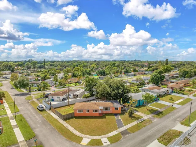 Corner lot residence featuring a paved driveway, exterior stucco finish, and a shingle roof