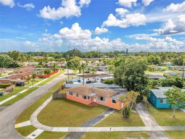 Single-story residence featuring a hipped roof, brick-veneer exterior, concrete driveway, and mature landscaping