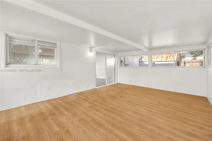 Interior space featuring wood-finish flooring, sliding glass door, and multiple horizontal sliding windows