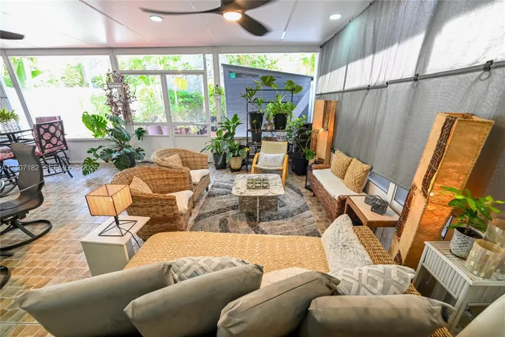 Screened-in patio featuring decorative tile flooring, ceiling-mounted fan, recessed lighting, and large screen panels