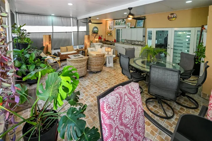 Enclosed patio featuring tile flooring, built-in cabinetry, recessed lighting, and dual ceiling fans