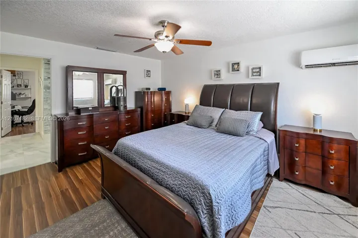 Wood-finish flooring, wall-mounted ductless air conditioning unit, and ceiling fan with integrated light fixture