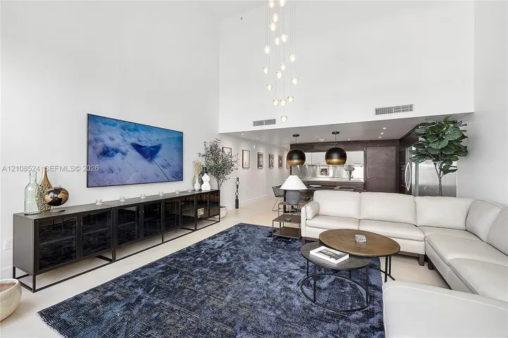 Double-height ceiling featuring a multi-globe chandelier, recessed lighting, and large-scale architectural volume