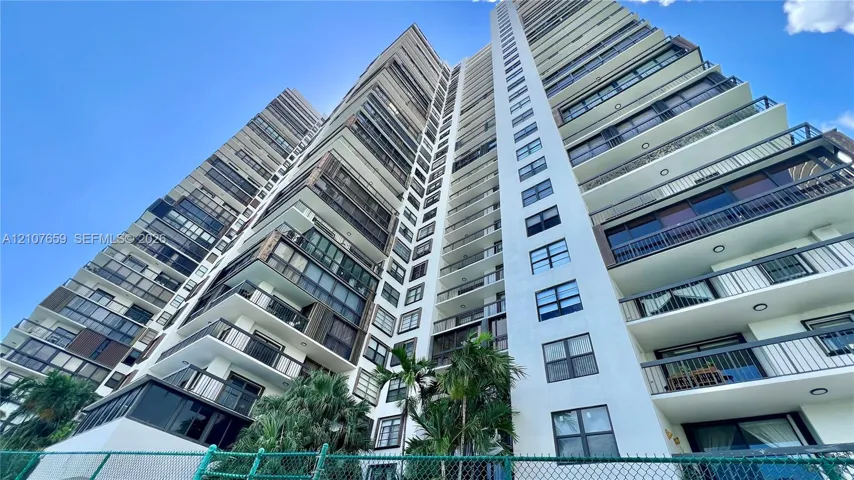 High-rise residential exterior featuring stacked private balconies, floor-to-ceiling glass windows, and reinforced concrete facade