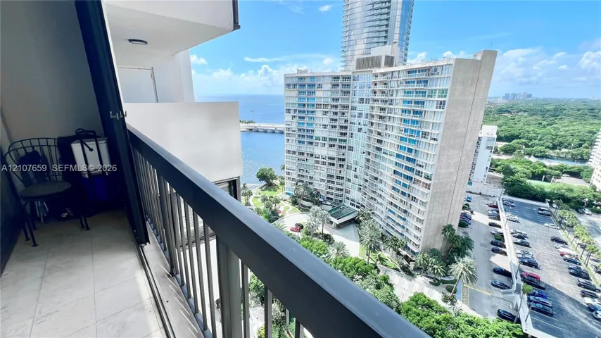 Covered balcony featuring tile flooring and a black metal railing