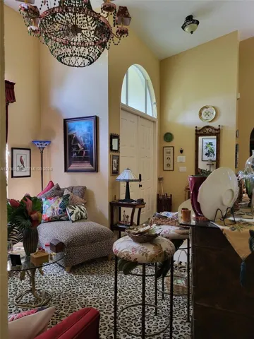 Vaulted ceilings featuring an arched transom window and a decorative multi-tiered chandelier
