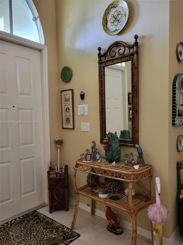 Entryway featuring a multi-panel door with an arched transom window and tile flooring