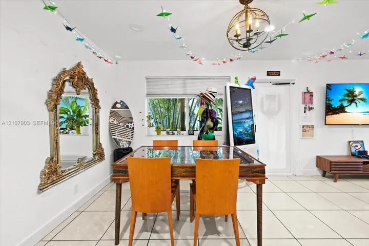 Interior space featuring large-format tile flooring, a statement orb chandelier, and a wide window with integrated roller shade