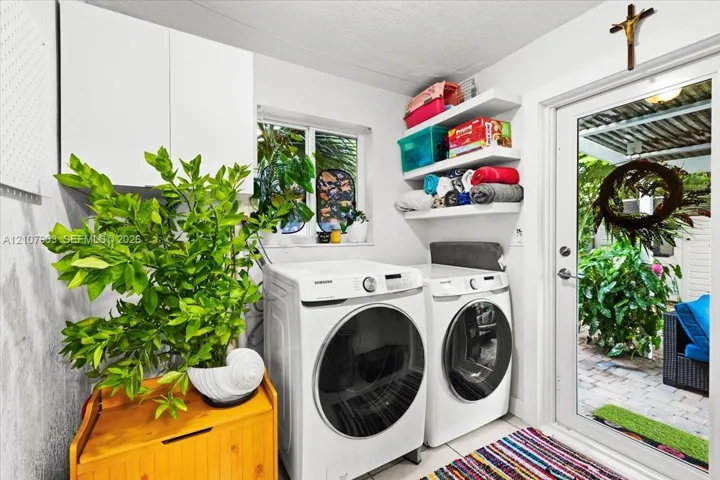 Laundry area featuring white cabinetry, tiered wall-mounted shelving, and a glass-paneled exterior door