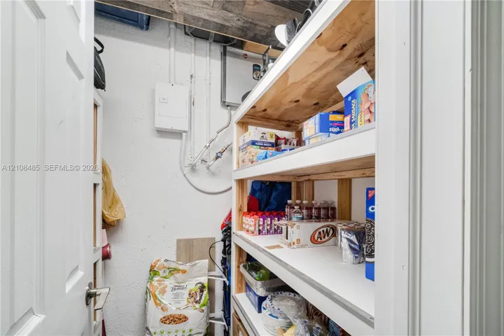 Storage space featuring custom-built wood shelving units and white painted walls