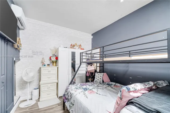 Textured white brick-pattern wall, high-contrast dark blue accent walls, wood-finish flooring, and wall-mounted climate control unit