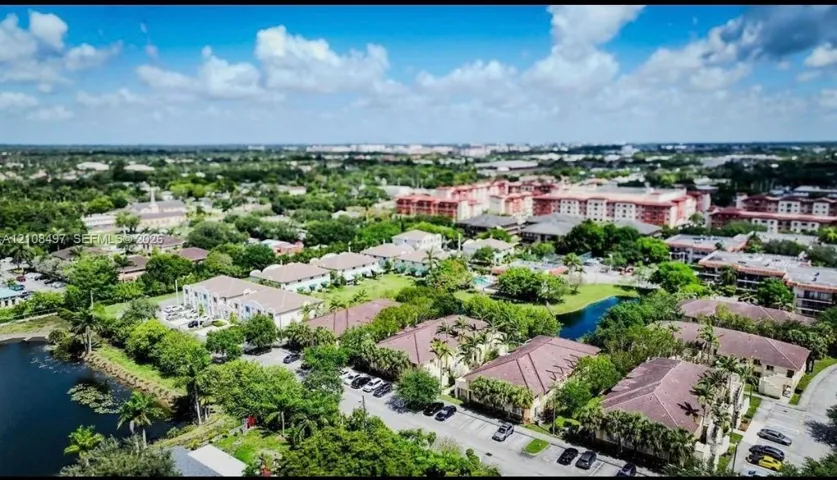 Aerial perspective featuring multi-story residential buildings with hipped tile roofs, established tree canopy, and waterfront areas