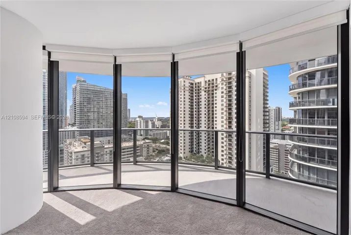 Curved balcony with glass railing, floor-to-ceiling windows, and wall-to-wall carpeting