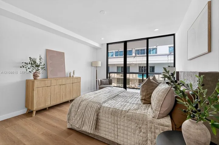 Floor-to-ceiling windows with black frames, wood-finish flooring, and recessed ceiling lighting