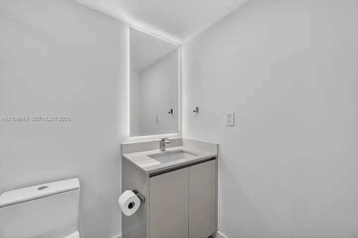 Modern vanity with a countertop basin, LED-backlit mirror, and chrome faucet fixture