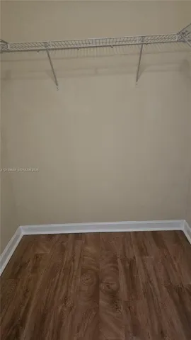 Walk-in closet featuring wire shelving and wood-finish flooring