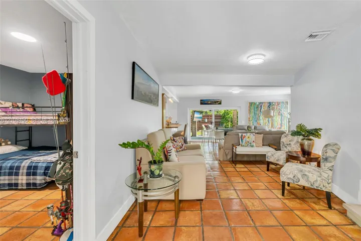 Terra-cotta tile flooring throughout and sliding glass doors leading to the outdoors