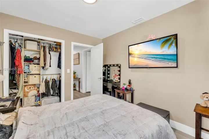 Neutral wall tones, recessed ceiling lighting, and a reach-in closet featuring built-in shelving
