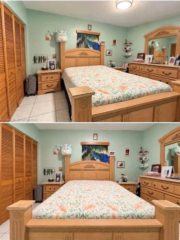 Bedroom featuring floor-to-ceiling louvered-door closets, tile flooring, and a glass-paneled wall-mounted corner shelf
