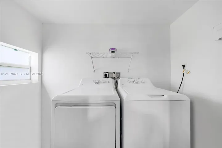Laundry area featuring a window, built-in wire shelving, and dedicated utility hookups