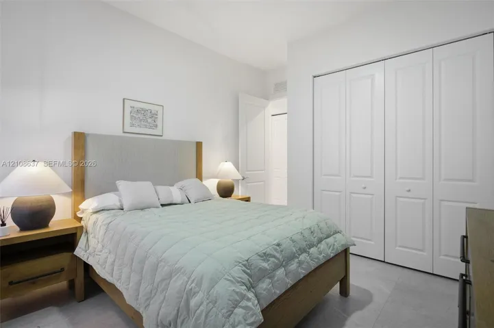 Room featuring neutral wall tones, large format tile flooring, and a floor-to-ceiling closet with white paneled bi-fold doors